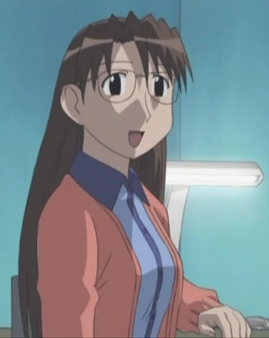 Yomi glancing at Tomo, currently off-screen, while at her desk in her bedroom. She is wearing a peach-colored jacket with a blue polo shirt and has long, brown hair.