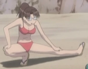 Yomi, with her hair pulled back in a ponytail, performs leg stretches on the beach while wearing a pink two-piece swimsuit and sandals.